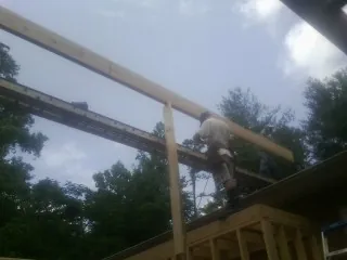 Carpenter setting a ridge beam over a new addition frame — Ice Dam Removal by Roofing Brothers in Fincastle