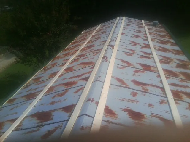 Rusted metal roof panels with new wood purlins before replacement — Storm Damage Roof Repair in Fincastle by Roofing Brothers