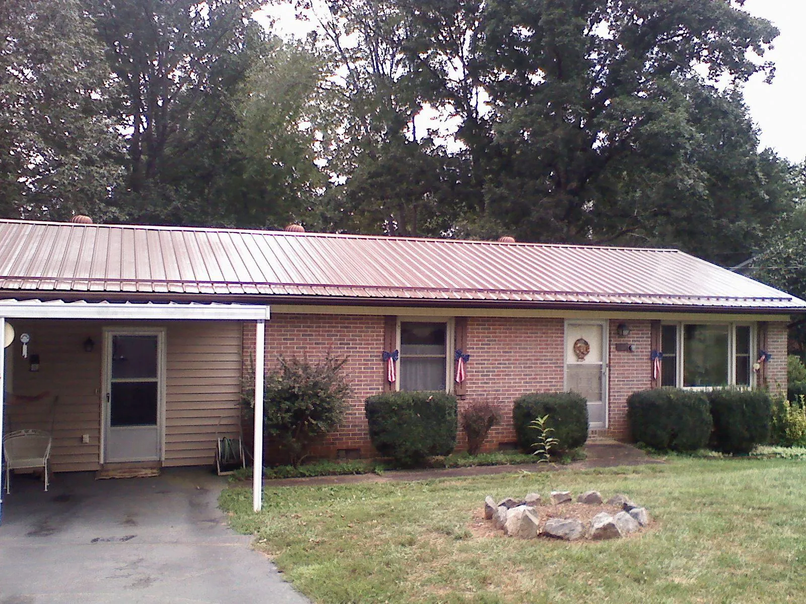 Bronze metal roof and carport on a brick ranch home — Roof Repair work by our crew in Fincastle
